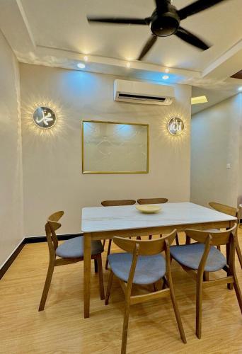 a dining room table with chairs and a ceiling fan at 3N Homestay Putrajaya in Putrajaya