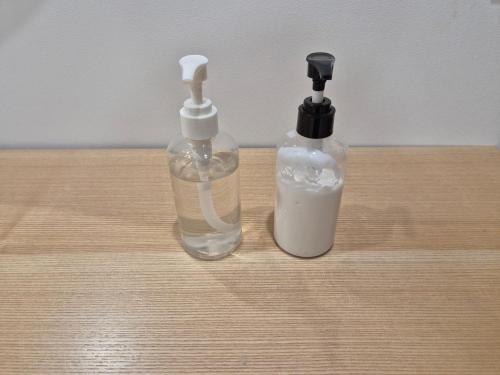 two glass bottles sitting on top of a wooden table at Gwang Jang Hotel in Busan