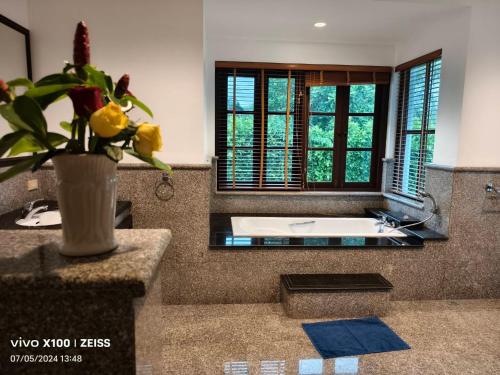 uma casa de banho com uma banheira e um vaso com uma planta em Project 17 em Hua Hin