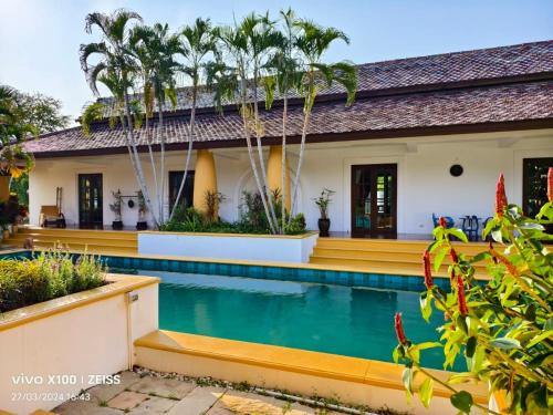 a house with a swimming pool and palm trees at Project 17 in Hua Hin