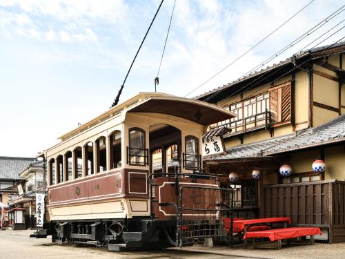 an old train car parked in front of a building at REF Kyoto Hachijoguchi by VESSEL HOTELS in Kyoto