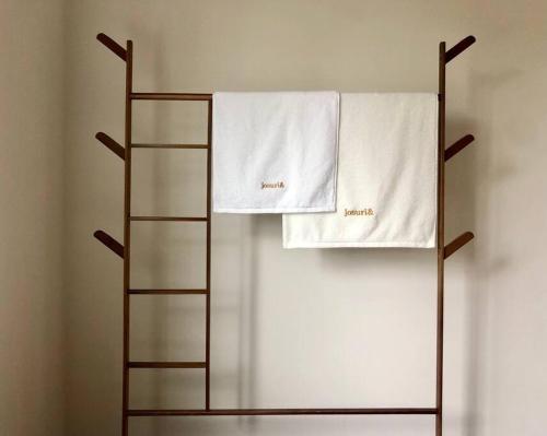 a towel rack with two white towels on it at Josuri& in Jeju