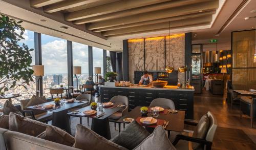 a restaurant with tables and chairs with a view at Rosewood Phnom Penh in Phnom Penh