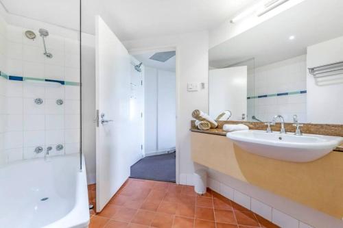 bagno con lavandino, doccia e vasca di 'Towering Palms' Resort-style Stay with a Separate Studio a Darwin
