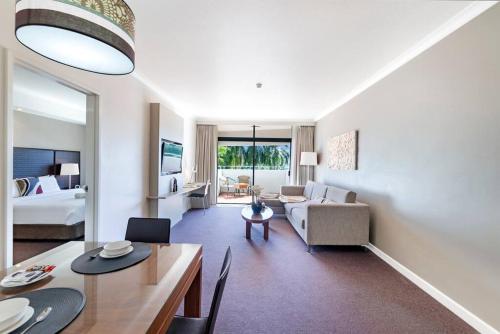 un ampio soggiorno con divano e tavolo di 'Towering Palms' Resort-style Stay with a Separate Studio a Darwin