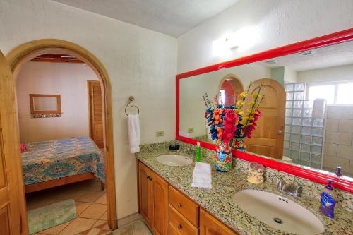une salle de bain avec un lavabo, un miroir et un lit dans l'établissement Las Palmas Resort, à Puerto Peñasco
