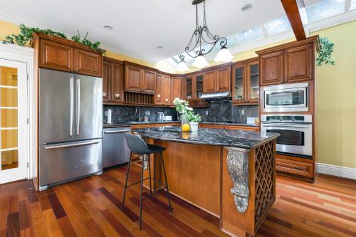 a kitchen with wooden cabinets and stainless steel appliances at Charming Retreat on Cypress Street, Your Home Away from Home in Vancouver