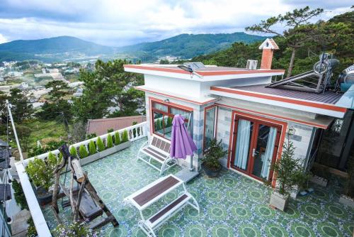 Cette maison dispose d'une terrasse avec des chaises et une vue. dans l'établissement Tường Vy Homestay Đà Lạt, à Đà Lạt