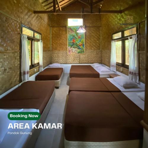 a row of beds in a room with windows at Bamboo Sanctuary Pancawati Resort Bogor in Ciherangsating