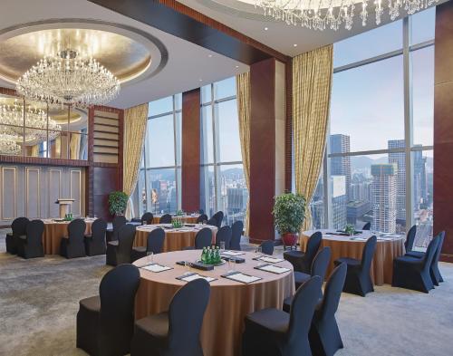 a conference room with tables and chairs and large windows at Futian Shangri-La, Shenzhen,Near to Shenzhen Convention&Exhibition Centre, Futian Railway Station in Shenzhen