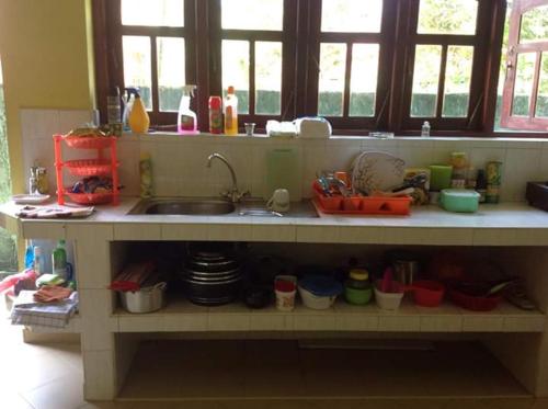 - un comptoir de cuisine avec évier et beaucoup de vaisselle dans l'établissement Lagoon Apartments Beruwala, à Beruwala