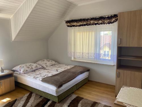a small bedroom with a bed and a window at Pokoje Gościnne Jolka in Ustronie Morskie