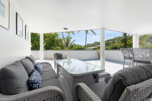 a living room with chairs and a glass table at Marina Terraces Port Douglas in Port Douglas