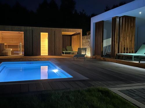 a swimming pool on a deck next to a house at Leśna Polana Domki in Okuninka
