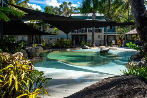una piscina con sombrilla en un complejo en Marlin Cove Holiday Resort, en Trinity Beach