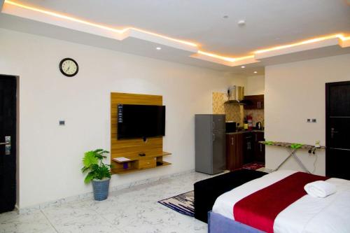 Schlafzimmer mit einem Bett und einem Flachbild-TV in der Unterkunft D2 Studio Apartment in Lagos
