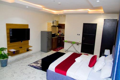 a bedroom with a bed and a flat screen tv at D2 Studio Apartment in Lagos