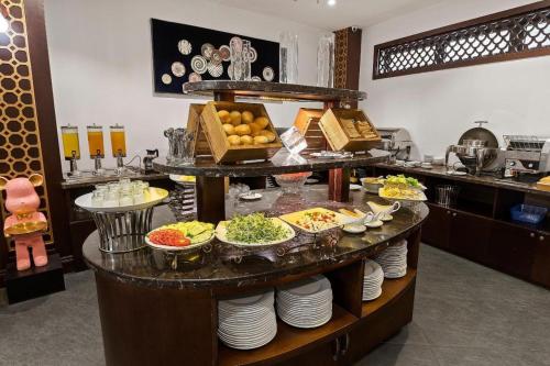 una línea de buffet con platos de comida en una mesa en 22Land Residence Hotel&Spa Ha Noi en Hanoi