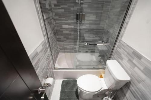 a small bathroom with a toilet and a shower at Stylish 5 Bedroom Apt in NYC! in New York