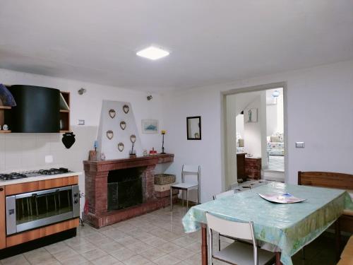 a kitchen with a table and a fireplace at Il giardino di Emilia in Raviscanina
