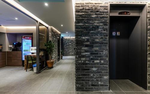 a room with a brick wall and a hallway at Hotel Yaja Terminal Branch in Jeonju