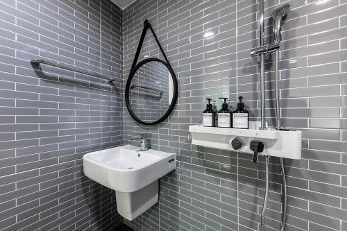 a white bathroom with a sink and a mirror at Hotel Yaja Terminal Branch in Jeonju