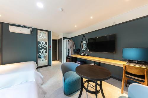 a hotel room with a bed and a desk with a television at Hotel Yaja Terminal Branch in Jeonju
