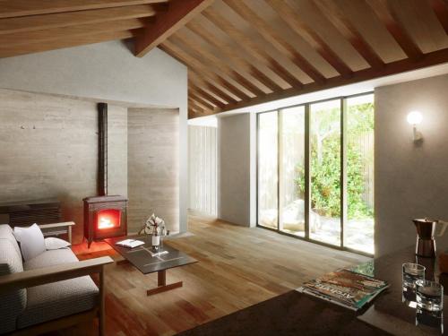 ein Wohnzimmer mit einem Sofa und einem Kamin in der Unterkunft Hakone Retreat villa 1f in Hakone