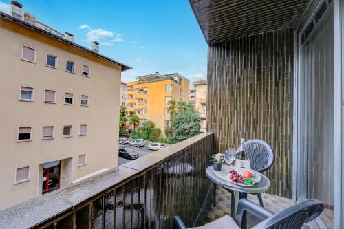 a small table on a balcony with a view of a city at Moonlight - Happy Rentals in Lugano
