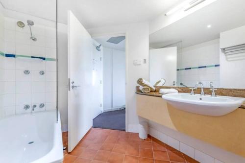a bathroom with a sink and a shower at Sky-high Waterfront Living across Two Apartments in Darwin