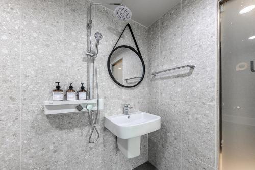 a bathroom with a sink and a shower and a mirror at Hotel Yaja Terminal Branch in Jeonju