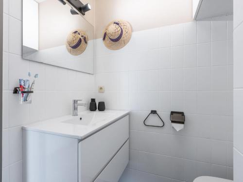 een witte badkamer met een wastafel en een toilet bij Apartment on the 8th floor with terrace in Middelkerke
