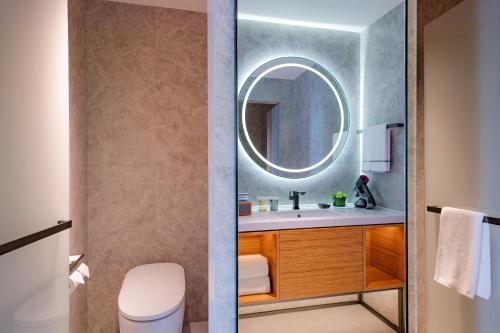 a bathroom with a sink and a mirror at UrCove by HYATT Futian CBD in Shenzhen