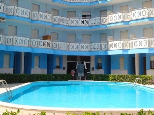 una gran piscina frente a un edificio en Inviting apartment by the beach, en Porto Santa Margherita