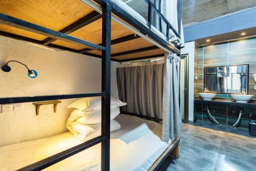 a room with two bunk beds and a bathroom at Zhangjiajie Yeah Hostel in Zhangjiajie