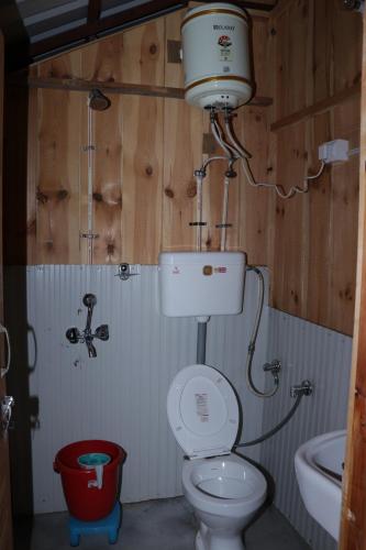 La salle de bains est pourvue de toilettes et d'un lavabo. dans l'établissement Trekking Cougars Huts, à Dharamshala