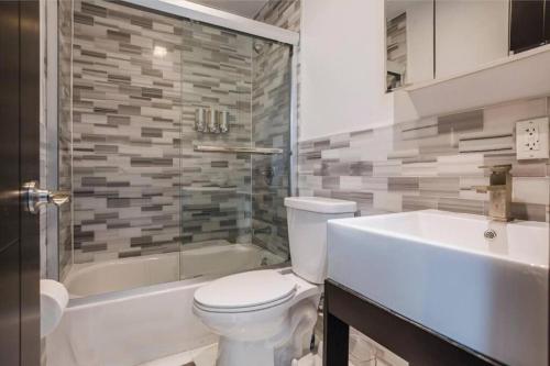 uma casa de banho com um WC, uma banheira e um lavatório. em 5-Bedroom New York Apartment em Nova York