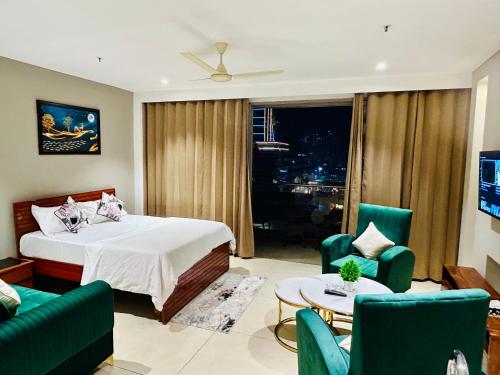 - une chambre avec un lit, des chaises et une table dans l'établissement Luxury Studio with Patio by Tulip Homes, à Gurgaon