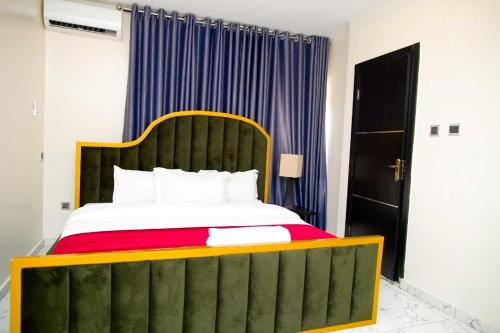 U2 One Bedroom Apartment في لاغوس: غرفة نوم بسرير كبير مع اللوح الاخضر