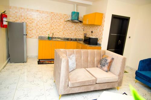 U2 One Bedroom Apartment في لاغوس: غرفة معيشة مع كرسي في مطبخ