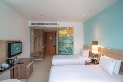 a hotel room with two beds and a television at Holiday Inn Express Phuket Patong Beach Central by IHG in Patong Beach