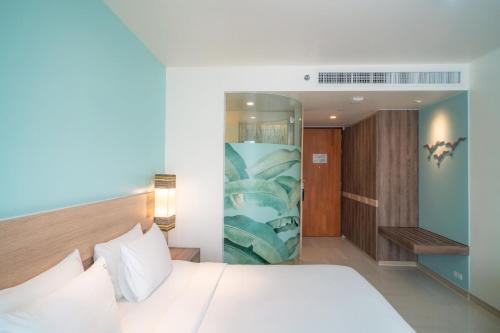 a bedroom with a bed and a glass wall at Holiday Inn Express Phuket Patong Beach Central by IHG in Patong Beach