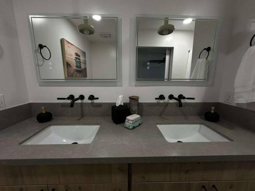 a bathroom with two sinks and a large mirror at Hoʻonānea I Loko Kailua in Kailua