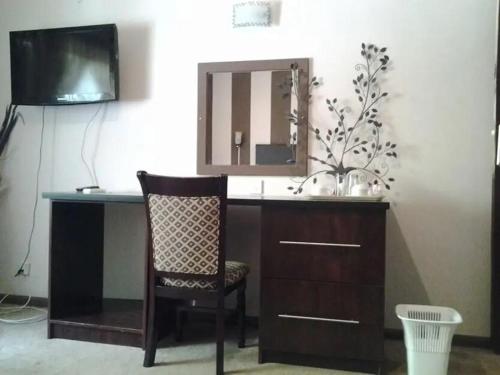Habitación con escritorio con espejo y silla. en Leopards road room, en Lusaka