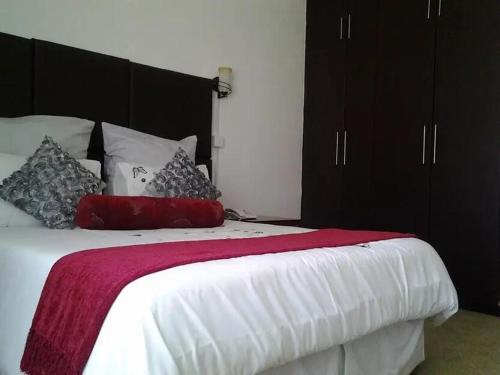 um quarto com uma cama grande e armários pretos em Leopards road room em Lusaka