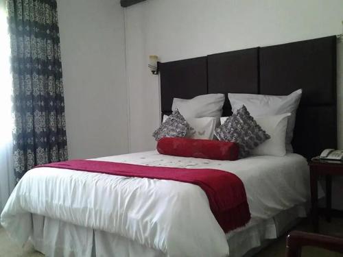 Un dormitorio con una cama grande con almohadas. en Leopards road room en Lusaka