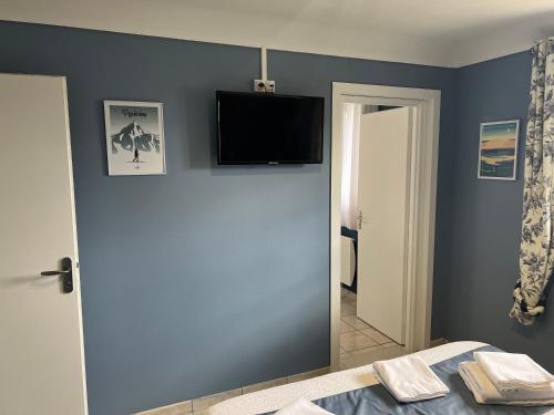 a bedroom with a bed and a television on the wall at Casa Di fiore in Maubourguet