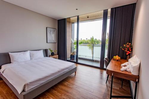 een slaapkamer met een bed en een tafel met een raam bij LUXURY VILLA with 5 BEDROOMS RIVER VIEW in Da Nang