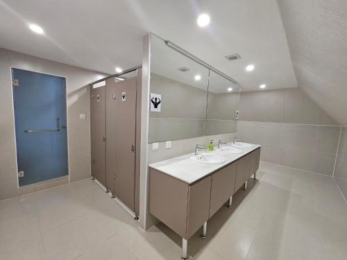 Moncozy guest house في أولان باتور: حمام به مغسلتين ومرآة كبيرة