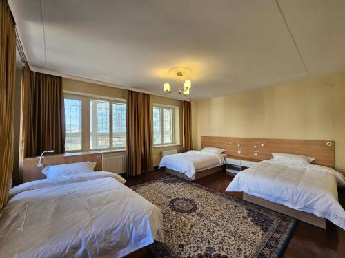 um quarto com 2 camas e 2 janelas em Moncozy guest house em Ulaanbaatar